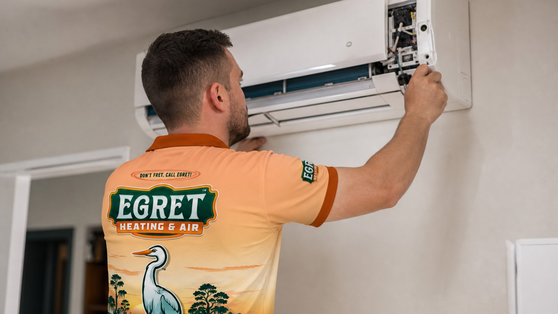Egret technician servicing an indoor air conditioning unit.